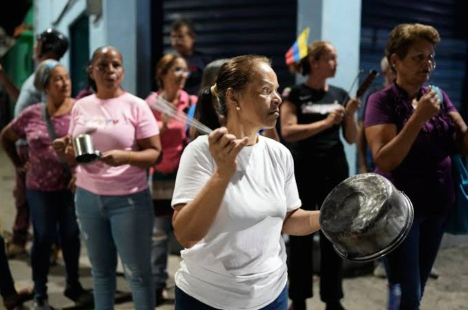 Varias personas golpean cacerolas durante una protesta contra los cortes de electricidad en San Mateo, Venezuela, el martes 18 de agosto de 2026. 