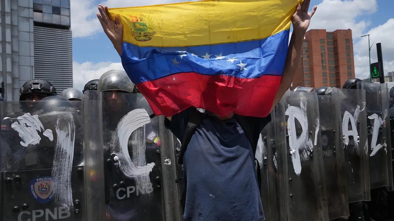 Un hombre ondea una bandera de Venezuela durante una protesta para exigir justicia para Carmen Navas, un día después de su muerte, el lunes 18 de mayo de 2026, en Caracas. 